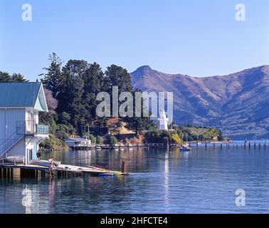 Der Bootsschuppen und Leuchtturm am Wasser, Beach Road, Akaroa, Banks Peninsula, Canterbury Region, Neuseeland Stockfoto