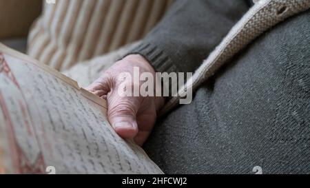 Hände, Nahaufnahme faltige Hand einer alten älteren Frau oder Mann mit Buch in arabisch. Hand hält koran, heilige Buch der muslime oder islam. Religiöse concep Stockfoto