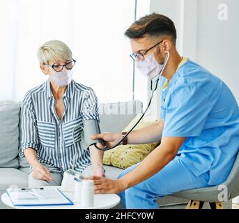 Krankenschwester Arzt Senior care Betreuer Hilfe überprüfen Untersuchung Blutdruck überprüfen Puls Ruhestand Haus Stethoskop Pflege ältere Mann Frau Gesundheit Stockfoto