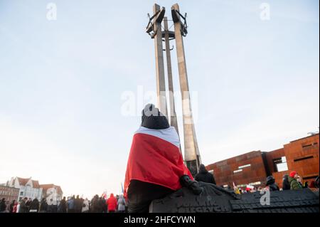 Danzig, Polen. 15th Januar 2022. Eine Frau, die mit einer polnischen Flagge gewickelt ist, nimmt an der Demonstration Teil."Stoppt die Trennung von Sanitäranlagen", "stoppt die gewaltsame", "freie Menschen" - solche Slogans waren im Zentrum von Danzig zu hören, während die Gegner von Zwangsimpfung und gesundheitlicher Segregation protestierten. Fast tausend Menschen nahmen an dem marsch Teil. Wie sie argumentierten, stimmten sie nicht zu: "Lockdown, Entbehrung von Freiheit und grundlegenden Bürgerrechten, Fütterung der Gesellschaft mit Lügen und Angst durch die Mainstream-Medien, Einführung schädlicher Gesetze Limit Credit: SOPA Images Limited/Alamy Live News Stockfoto