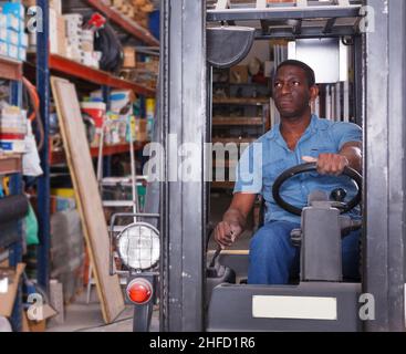 Arbeiter, der den Gabelstapler im Laden fährt Stockfoto
