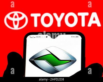 In dieser Abbildung ist das Ranz Toyota-Tochterlogo auf einem Smartphone-Bildschirm mit dem Toyota-Logo im Hintergrund zu sehen. Stockfoto