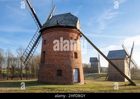Alte Windmühlen. Gebäude aus Holz und Mauerwerk. Traditionelle alte polnische ländliche Holzhäuser und Bauernhöfe. Ethnographisches Freilichtmuseum Dziekanowice Stockfoto