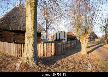 Alte Gebäude aus Holz und Mauerwerk. Traditionelle alte polnische ländliche Holzhäuser und Bauernhöfe. Ethnographisches Freilichtmuseum in Dziekanowice, Polen Stockfoto