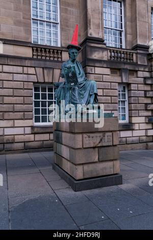 Die Statue des schottischen Philosophen David Hume auf der Royal Mile in Edinburgh, mit einem roten Verkehrskegel auf dem Kopf Stockfoto