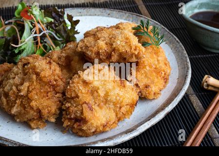 Tonkatsu oder frittiertes Schweinefleisch, ein traditionelles japanisches Gericht, das aus paniertem Fleisch mit Gemüsesalat besteht. Stockfoto