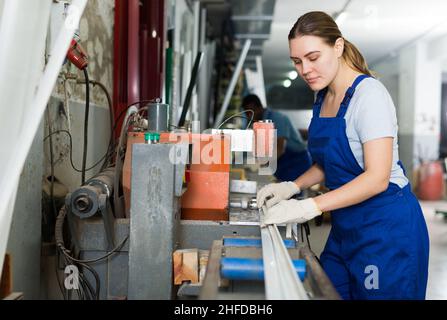 Weibliche Master ist das Arbeiten mit der Maschine in das Fenster Workshop. Stockfoto