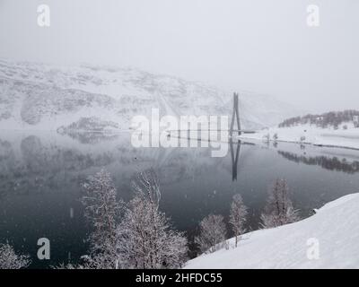 Der Kafjord in Alta Municipality in Troms Og Finnmark County, Norwegen, wird von einem Brückenschlag der europäischen Autobahn E06 überquert, die dem nördlichen Sho folgt Stockfoto