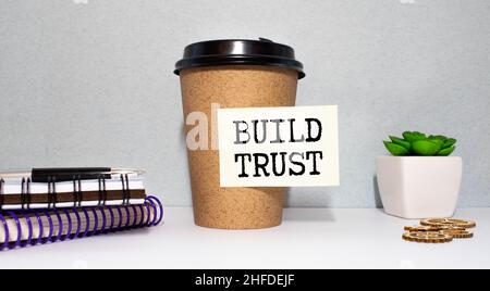 Geschäfts- und Finanzkonzept. Auf dem Tisch stehen ein Stift und ein Notizbuch mit den Aufschriften - Vertrauen aufbauen Stockfoto