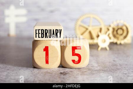 Kalender Reminder Veranstaltung Konzept. Holzwürfel mit Nummern und Monat am 15. Februar mit Sonnenlicht. Stockfoto