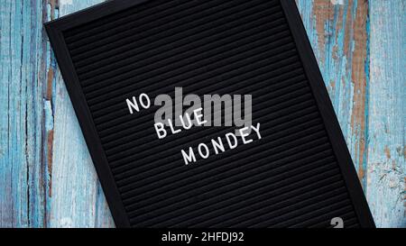 Blaues bannerkonzept am montag. Schwarzes Brett mit Text kein blauer montag auf blauem Holzhintergrund, Draufsicht, flach liegend Stockfoto