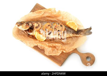 Holzbrett mit köstlichen Seebarsch Fisch, Zitrone und Pilze auf weißem Hintergrund Stockfoto