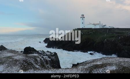 Wellen krachen bei Sonnenaufgang, nach einem Sturm. Fanad Head Leuchtturm. Küste der Grafschaft Donegal in Irland. Wilder atlantischer Weg Stockfoto