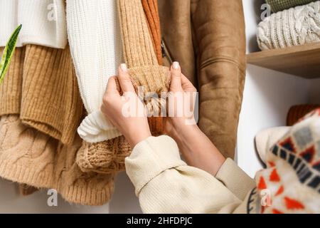 Frau mit hängendem Strickpullover im Kleiderschrank, Nahaufnahme Stockfoto
