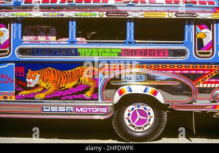 Ein Jeepney-Bus in Davao City auf der Insel Mindanao auf den Philippinen. Jeepneys, eine Form des öffentlichen Nahverkehrs, sind die bevorzugte Art, sich auf den Philippinen zu bewegen. Jeepney Busse sind immer in leuchtenden Farben und extravagant dekoriert. Stockfoto