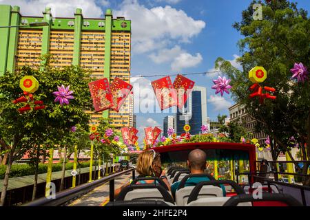 Touristen, die im offenen Bus sitzen und die Dekoration des chinesischen Neujahrsfestes sehen. Singapur. Stockfoto