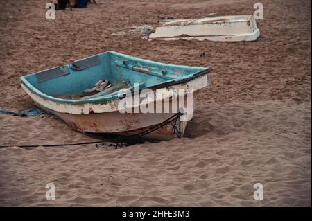 Altes, beschädigtes Boot, das am Sandstrand aufgegeben wurde Stockfoto