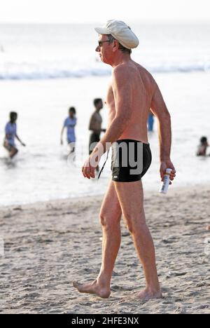 Ein älterer Mann mit weißer Mütze am Kuta Beach, Bali in Indonesien. Stockfoto