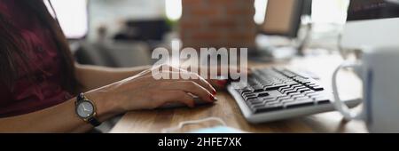 Weibliche Hände mit einer Uhr drücken die Tastatur Stockfoto