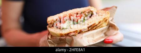 Frau hält ein Sandwich mit Füllung in den Händen Stockfoto