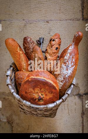 Laibe frisch gebackenes rustikales Brot in einem Korb, der in einer handwerklichen Bäckerei in Donostia oder San Sebastian, Spanien, ausgestellt wird Stockfoto