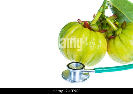 Nahaufnahme Stillleben garcinia atroviridis frische Früchte und Stethoskop, auf weißem Hintergrund. Kräutersauer schmeckt viel Vitamin C für eine gute Gesundheit. Gratis fo Stockfoto