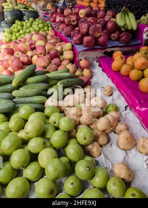 Winterfrüchte, die im Einzelhandelsgeschäft für den Verkauf in bengalen indien aufbewahrt werden. kul oder indische Jujube oder indische Pflaumen, Gurken und andere saisonale Früchte werden zusammen gehalten Stockfoto