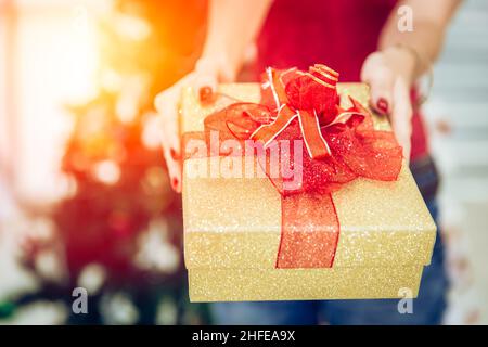Closeup Mädchen Hand geben Luxus Gold Geschenk-Box für die Feier des neuen Jahres. Stockfoto