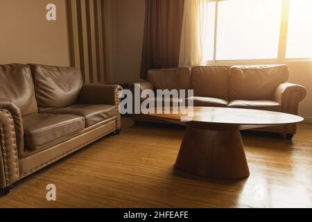 Wohnzimmer oder Warteraum Ledersofa mit Holztisch Vintage-Stil Dekoration braunen Farbton Stockfoto