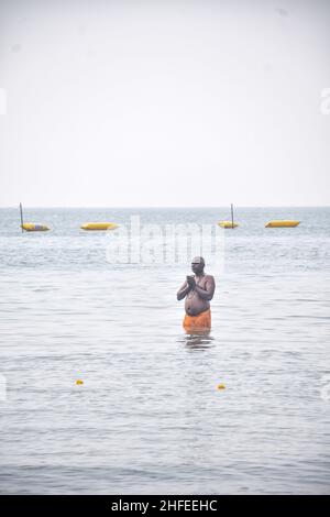 Ein Anhänger sah während der Feier Gebete im Meer opfern. Gangasagar ist ein Ort der Hindu-Wallfahrt, wo jedes Jahr am Tag des Makar Sankranti, Hindus versammeln sich, um ein heiliges Bad an der Konvergenz des Flusses Ganga und der Bucht von Bengalen zu nehmen. Nach dem Eintauchen beten alle Pilger im Kapil Muni Tempel. (Foto: Tamal Shee/SOPA Images/Sipa USA) Quelle: SIPA USA/Alamy Live News Stockfoto