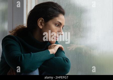 Gestresste junge hispanische Frau, die an negativen Gedanken leidet. Stockfoto