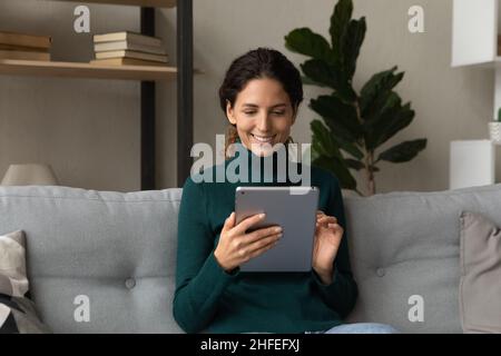 Glückliche junge lateinerin mit digitalem Tablet. Stockfoto
