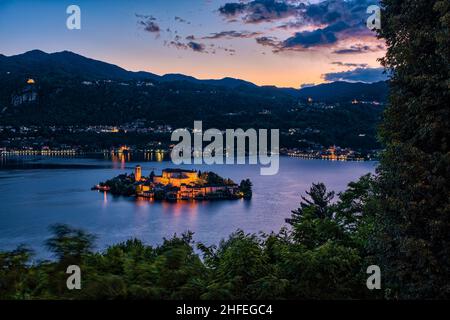 Luftaufnahme vom Sacro Monte auf der Insel St. Julius mit der Basilica di San Giulio in der Mitte des Ortasees, bei Sonnenuntergang Stockfoto