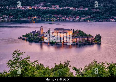 Luftaufnahme vom Sacro Monte auf der Insel St. Julius mit der Basilica di San Giulio mitten im Ortasee, nachts beleuchtet. Stockfoto