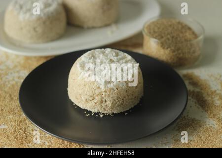 Gedünsteter Hirse-Mehl-Kuchen oder Hirse-puttu. Eine Vielzahl von Kerala Reis Dampfkuchen mit Scheckenhirse Mehl zusammen mit zerkleinerten Coconu Stockfoto