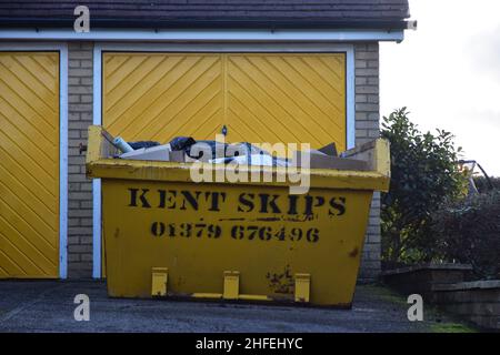 Yellow skip outside yellow Garagentore, suffolk, england Stockfoto