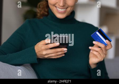 Nahaufnahme lächelnde junge Frau, die online für Waren bezahlt. Stockfoto