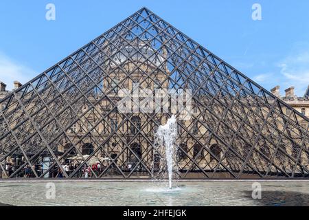 PARIS, FRANKREICH - 30. AUGUST 2019: Dies ist die große Pyramide des Louvre und einer der Brunnen im Hof von Napoleon. Stockfoto