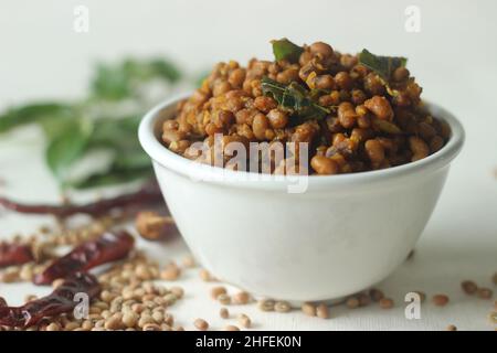 Gekochte rote Kuhpfeienbohnen rühren mit Schalotten und Knoblauch gebraten. Beliebte Beilage zu den Mahlzeiten in Kerala gemeinhin als Stir gebraten Vanpayar. Auf Weiß geschossen Stockfoto