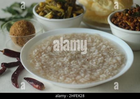 Reisbrei oder Kanji zusammen mit würzigem, kälteem Kokosnussrot-Chutney, gebratenen gekochten roten Kuhpeibohnen und gebratenen rohen Bananenscheiben. Ein Favorit m Stockfoto