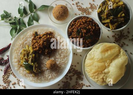 Reisbrei oder Kanji zusammen mit würzigem, kälteem Kokosnussrot-Chutney, gebratenen gekochten roten Kuhpeibohnen und gebratenen rohen Bananenscheiben. Ein Favorit m Stockfoto