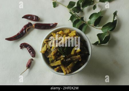 Kleine rohe Bananenscheiben mit Schalotten und Gewürzen umrühren. Die rohen Bananenscheiben sind dünn und lang. Beliebte Beilage für Mahlzeiten in Kerala häufig c Stockfoto