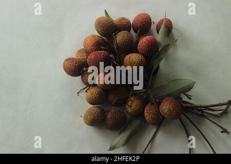 Litschi-Früchte auf weißem Hintergrund aufgenommen. Litchi chinensis auch buchstabiert litchi oder lichi, ist ein immergrüner Baum der Familie der Speckbeere oder Sapindaceae, gr Stockfoto