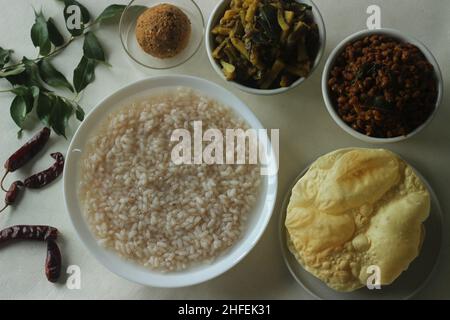 Reisbrei oder Kanji zusammen mit würzigem, kälteem Kokosnussrot-Chutney, gebratenen gekochten roten Kuhpeibohnen und gebratenen rohen Bananenscheiben. Ein Favorit m Stockfoto