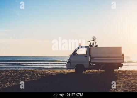 Auto der Reinigung am Strand bei Sonnenaufgang Stockfoto