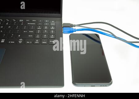 Kabel und Drähte, die mit dem Computer verbunden sind. Mit dem Laptop verbundene Internet-Netzwerkkabel. Internetkabel auf weißem Hintergrund Stockfoto