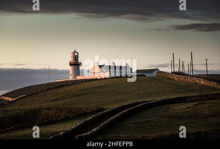 Galley Head, Cork, Irland. 16th. Januar 2022. Das Morgenlicht beginnt, den Leuchtturm in Galley Head, Co. Cork, Irland, zu erleuchten. - Credit; David Creedon / Alamy Live News Stockfoto