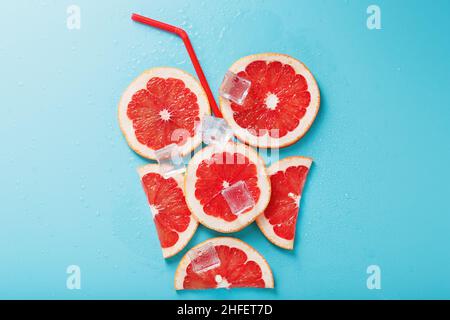 Eine Komposition aus Grapefruitscheiben und Eiswürfeln mit blauem Hintergrund in Form eines erfrischenden Getränks. Draufsicht, freier Platz Stockfoto