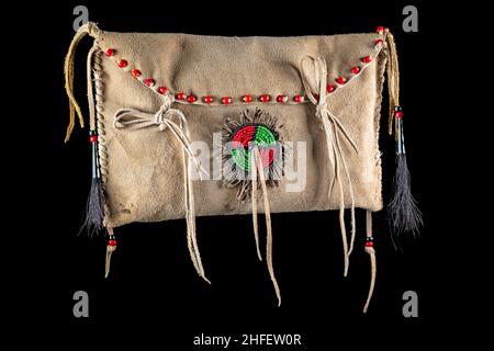 Sack der nordamerikanischen Indianer. Hergestellt aus Haut, bestickt mit bunten Glasperlen und Lederbändern auf schwarz isoliert Stockfoto