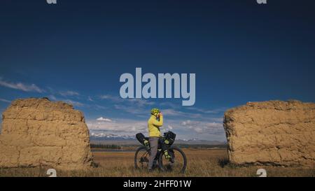 Der Mann reist auf gemischtem Terrain mit Bikepacking. Die Reise des Reisenden mit Fahrradtaschen. Sport Tourismus Bikepacking. Stockfoto